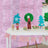 Colorful paper crafts displayed on a table with a pink backdrop.
