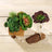 Artificial succulent arrangement in wooden box with decorative elements.