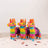 Colorful piñatas lined up against a plain background.