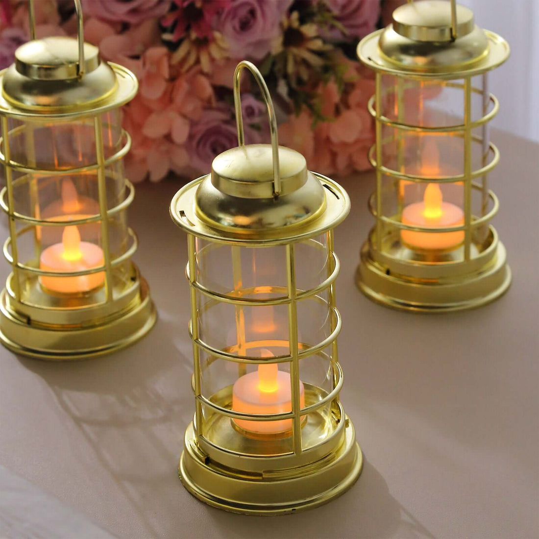 Gold lanterns with LED candles, perfect for ambiance or decor.