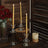 Elegant gold taper candles in crystal holders with decorative elements.