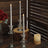 Elegant silver taper candles in glass holders on rustic wooden decor.