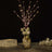 Decorative flower vase with illuminated branches and white flowers.