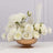 Elegant white rose arrangement in a copper bowl with feathers.