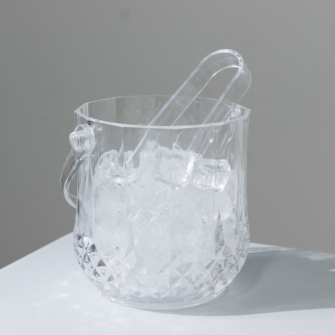 Crystal ice bucket with tongs and ice cubes inside
