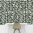 White rose floral wall mural with a modern chair in front.
