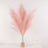 Pink pampas grass arrangement in a glass vase with gold base.
