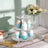 Cupcake stand with decorative cupcakes in pastel colors on a wooden table.