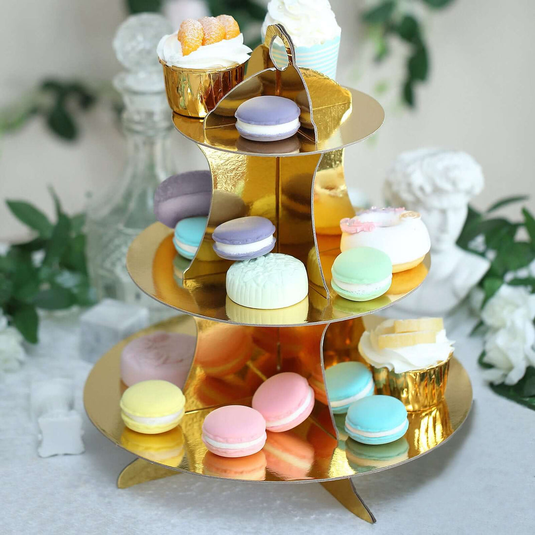 Elegant gold dessert stand filled with colorful macarons and treats.