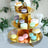 Elegant gold dessert stand filled with colorful macarons and treats.