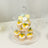 Three-tiered dessert stand with cupcakes and macarons.