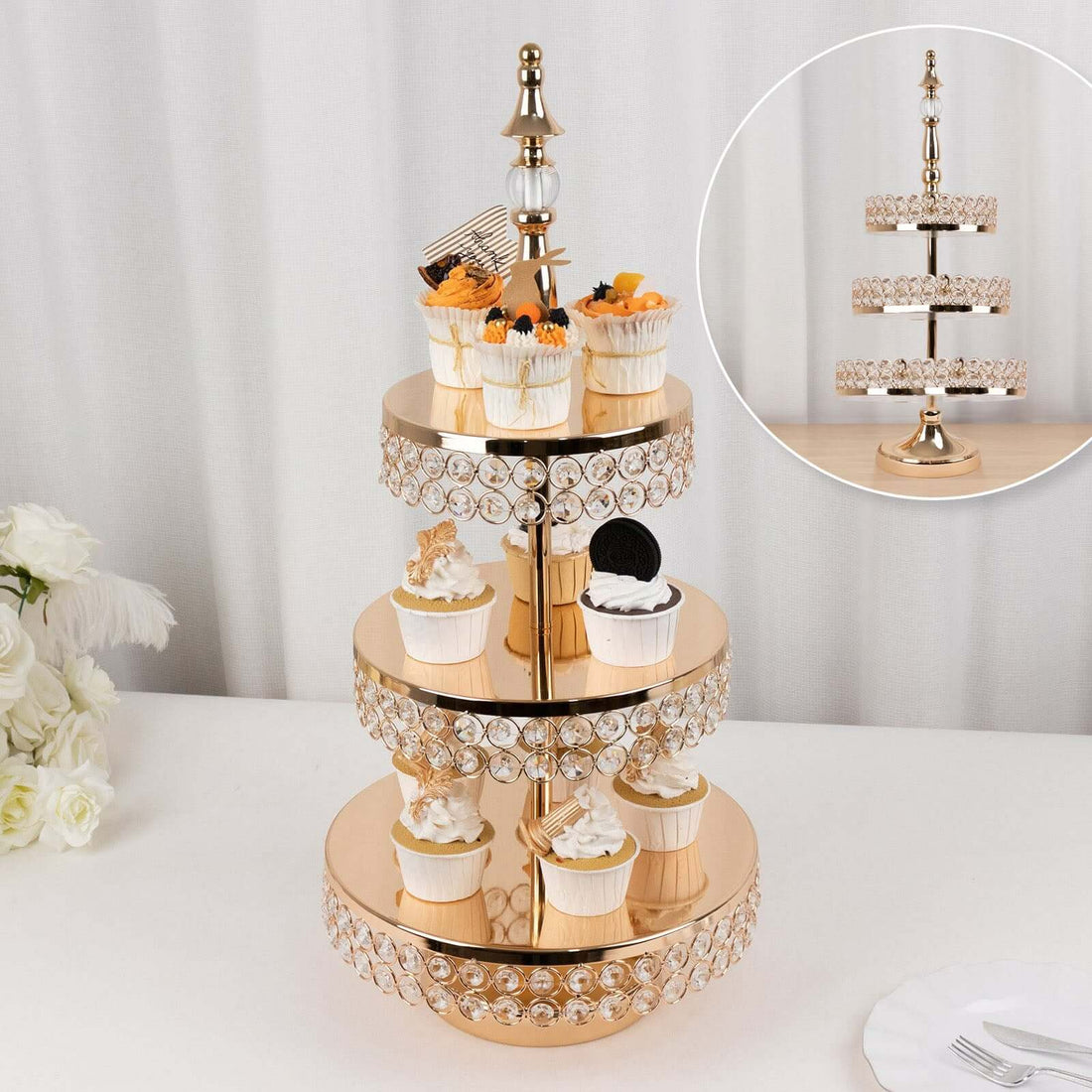 Elegant three-tier cupcake stand with decorative crystals and cupcakes.