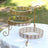 Elegant gold three-tier serving stand with intricate design.