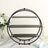 Black circular metal shelf with three tiers, styled with flowers and cupcakes.