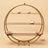 Gold circular shelf with pink desserts and floral accents.