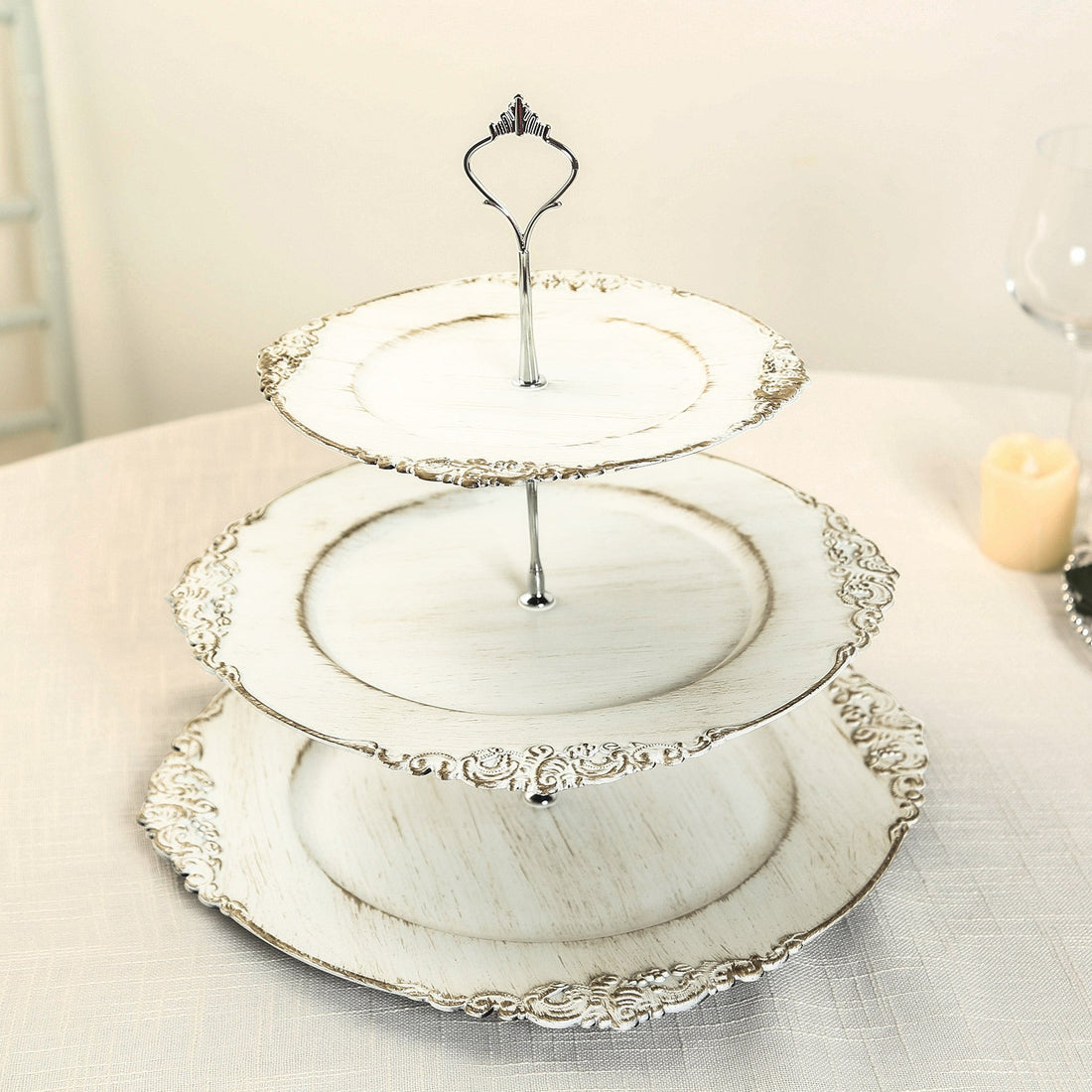 Three-tiered vintage cake stand with decorative edge.