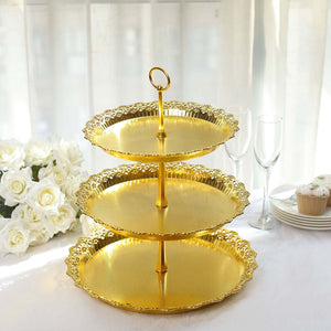 Three-tier gold serving stand with ornate design and handle.