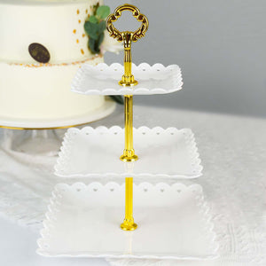 Three-tiered serving stand with a gold handle and scalloped white plates.