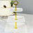 Three-tiered serving stand with a gold handle and scalloped white plates.