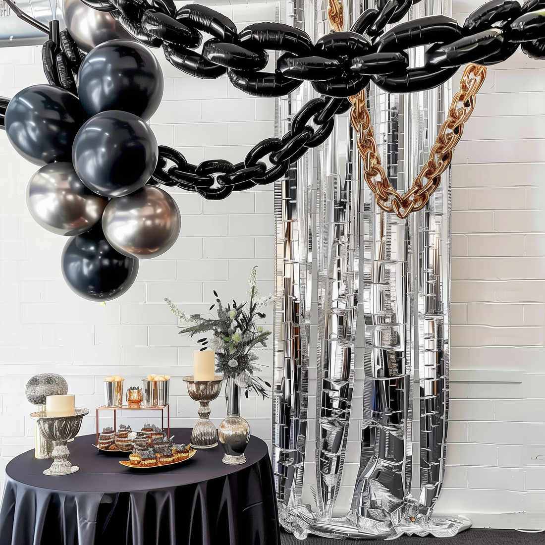 Decorative party setup with balloons, chains, and a dessert table.