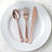 Rose gold cutlery set on a white plate.