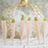 Pink decorative feathers with glittery gold tips arranged in a row.