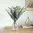 Eucalyptus leaves in a glass vase on a wooden table