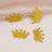Gold glitter crown embellishments on a soft fabric background.
