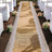 Burlap wedding aisle runner with lace trim and floral decor