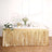 Gold fringe table skirt with floral arrangements and decorations for a festive event.