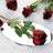 Red roses reflected in an oval mirror on a soft white background.