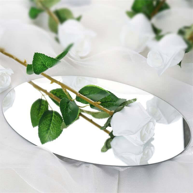 Oval mirror with white roses and green leaves reflection.