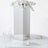 Mirrored vase with white flowers on a table setting.