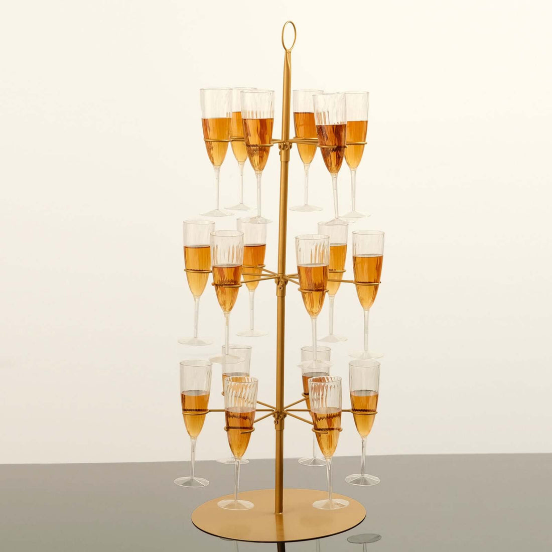 Gold champagne tower with glasses filled with champagne.