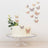 Butterfly-decorated cake on a glass stand with floral accents.