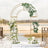 Elegant wedding arch adorned with white flowers and greenery in a scenic outdoor setting.