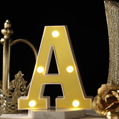 Illuminated letter A marquee light with gold decorative decor on black background