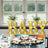 Illuminated "BABY" letters on a dessert table with cupcakes and sweets.