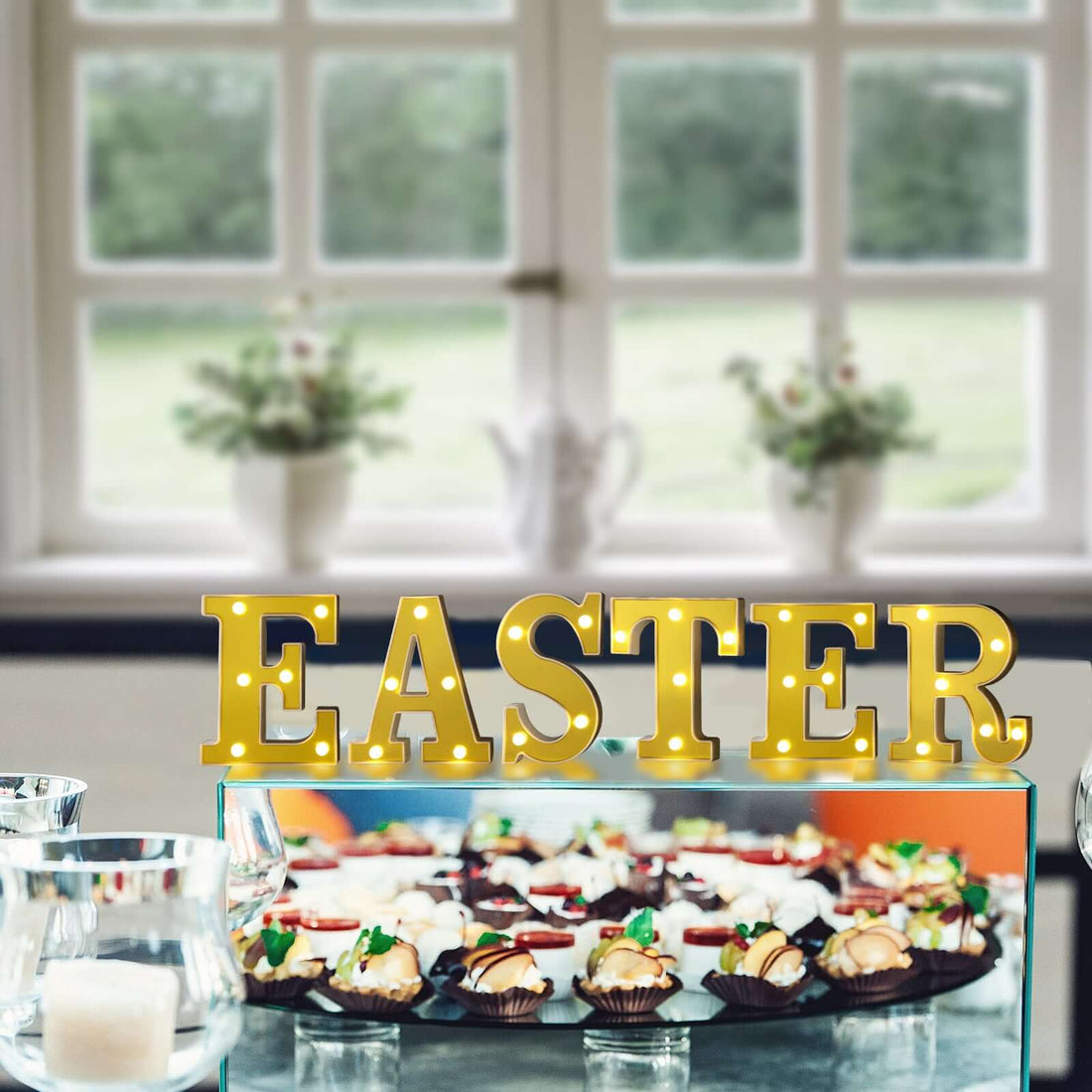 Easter marquee sign with decorated desserts in a festive setting.