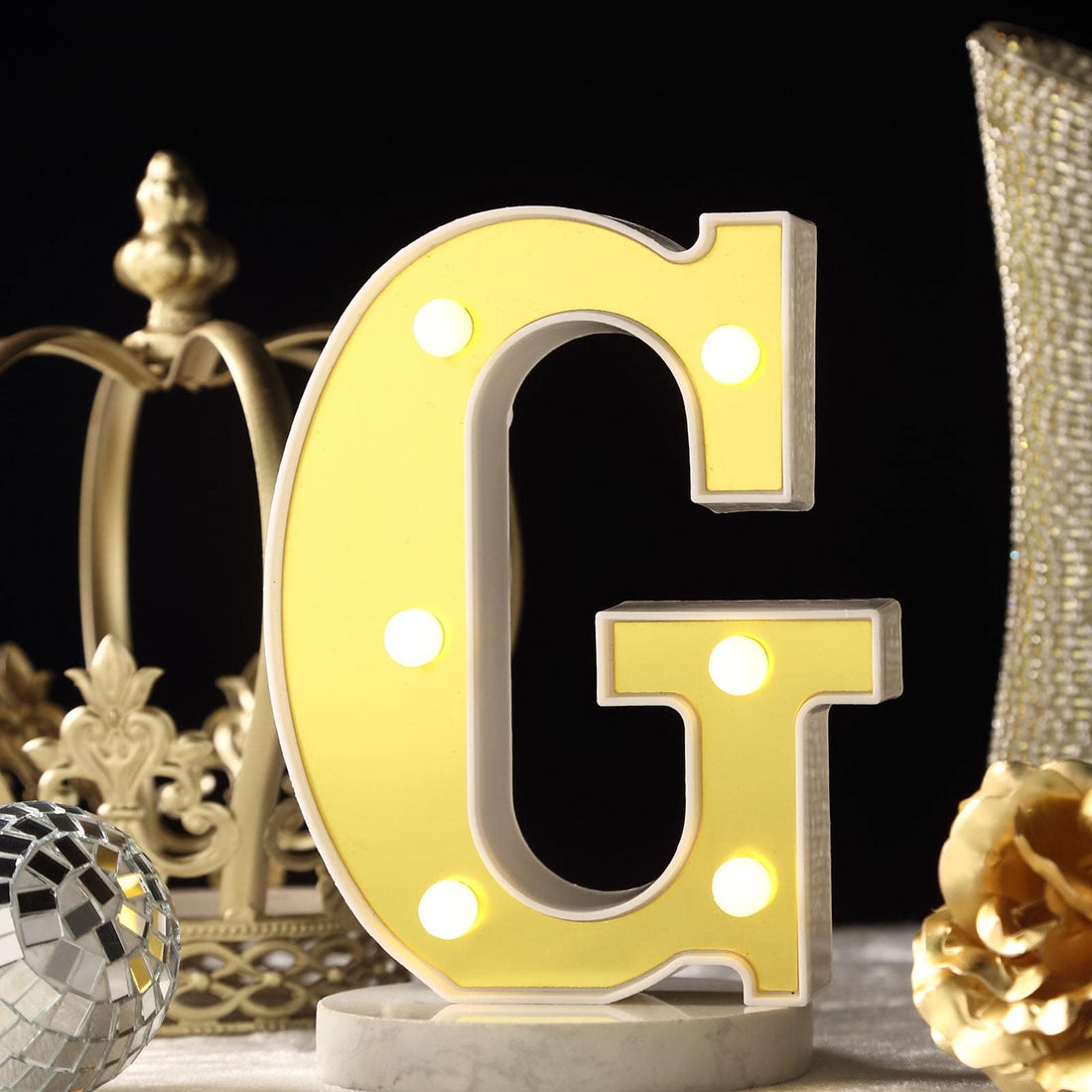 Light-up letter "G" marquee sign with bulbs, stylish decor piece.