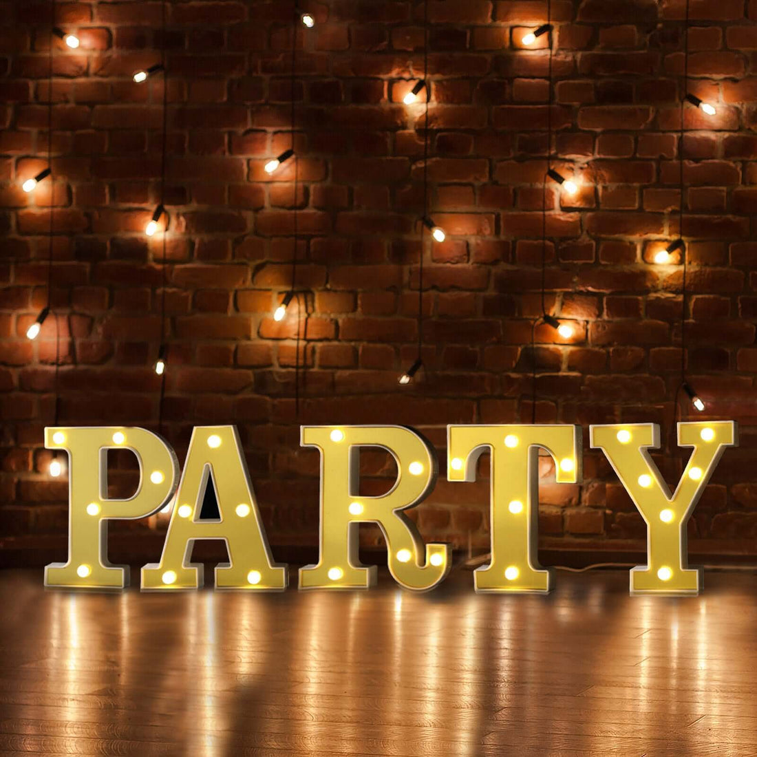Illuminated marquee letters spelling "PARTY" against a rustic brick wall.