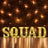 Illuminated "SQUAD" letter sign on a brick wall backdrop with string lights.