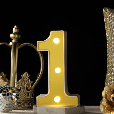 Illuminated number 1 marquee light with gold decor on black background