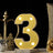 Yellow marquee number three with lights on a decorative table.