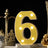 Illuminated yellow number 6 marquee light on a decorative table setting.