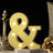 Yellow marquee ampersand sign with lights on a dark background.