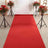 Red carpet with floral arrangements in stylish pots, perfect for events.