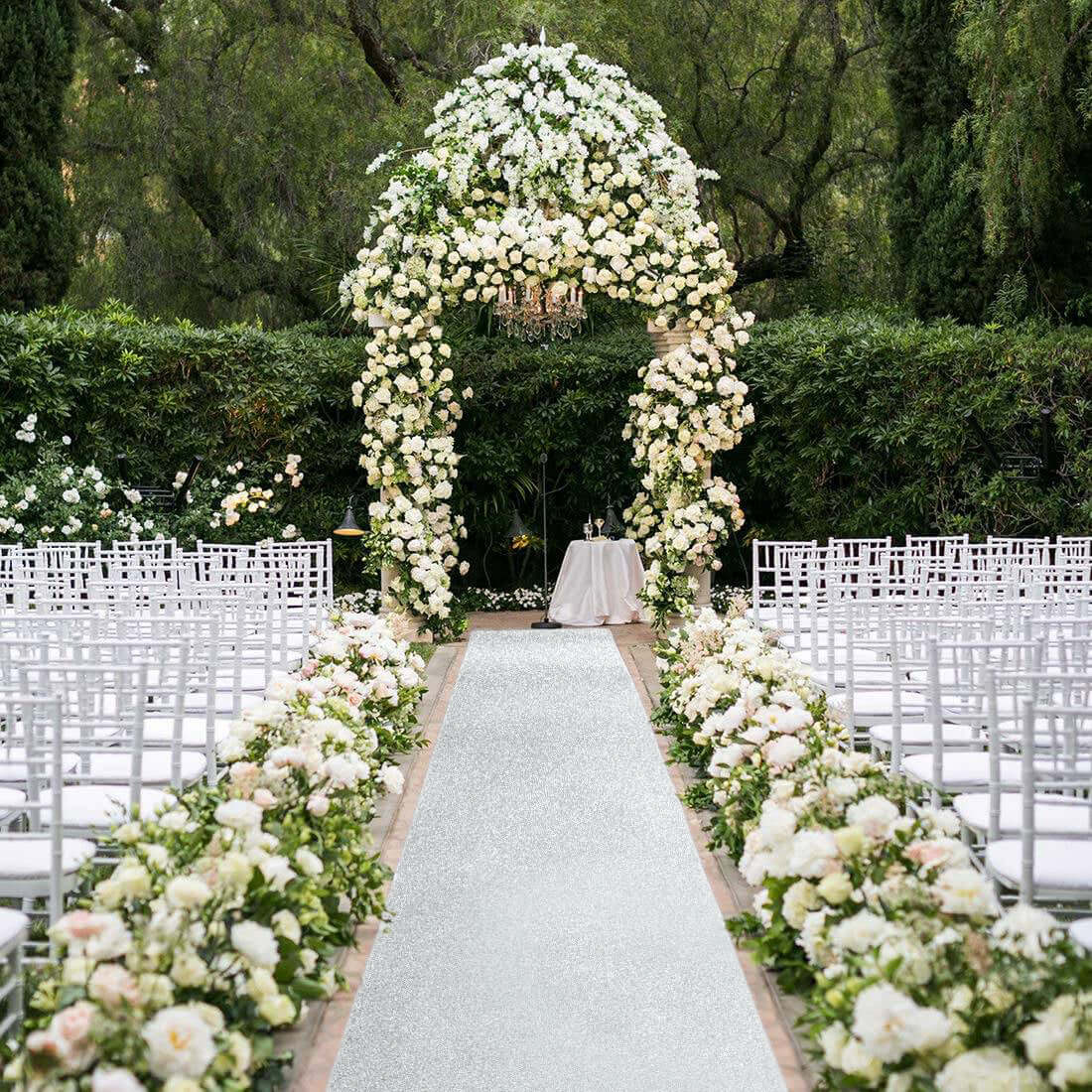 Elegant wedding arch adorned with white flowers and a floral aisle decor.