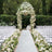 Elegant wedding arch adorned with white flowers and a floral aisle decor.