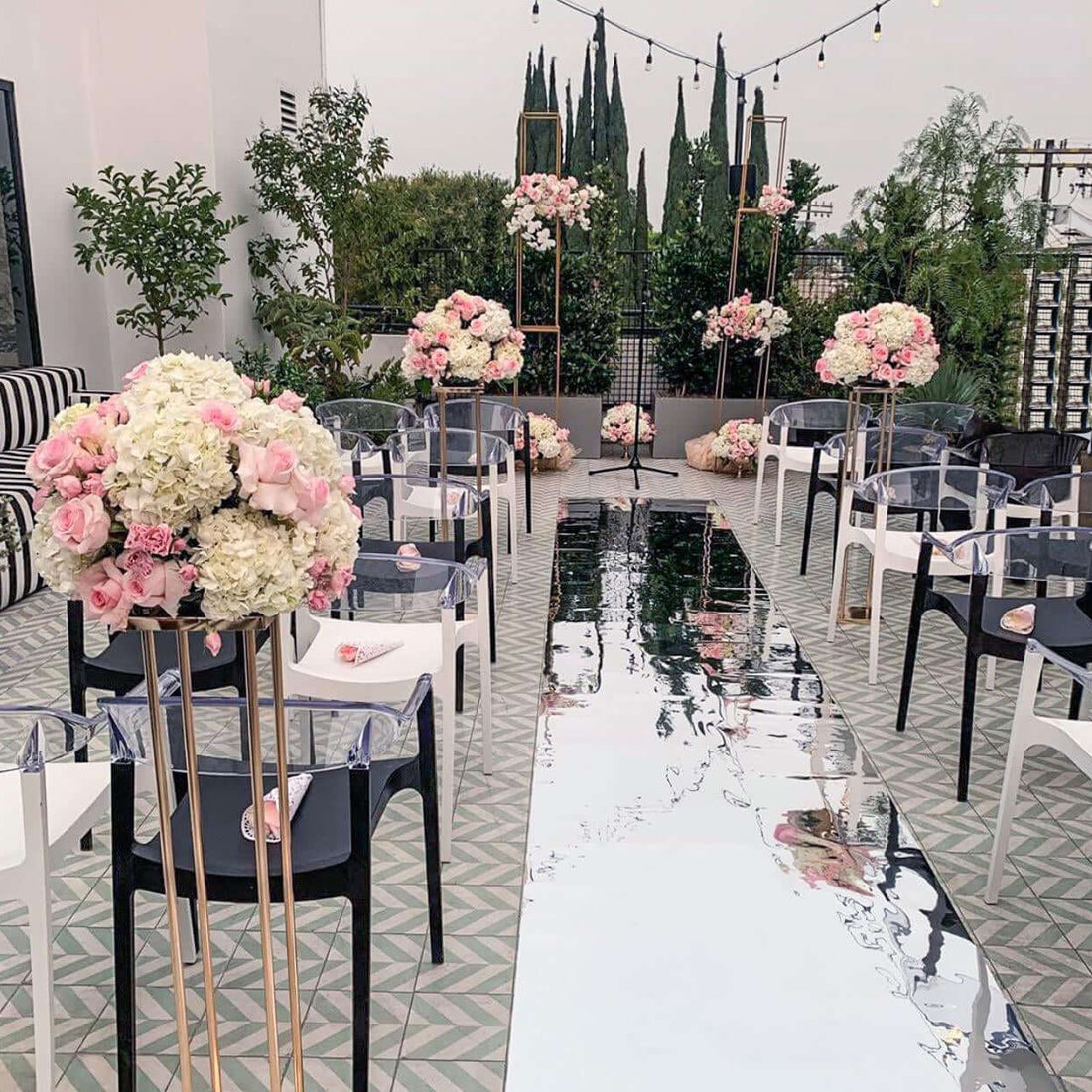 Elegant wedding setup with floral arrangements and mirrored aisle.